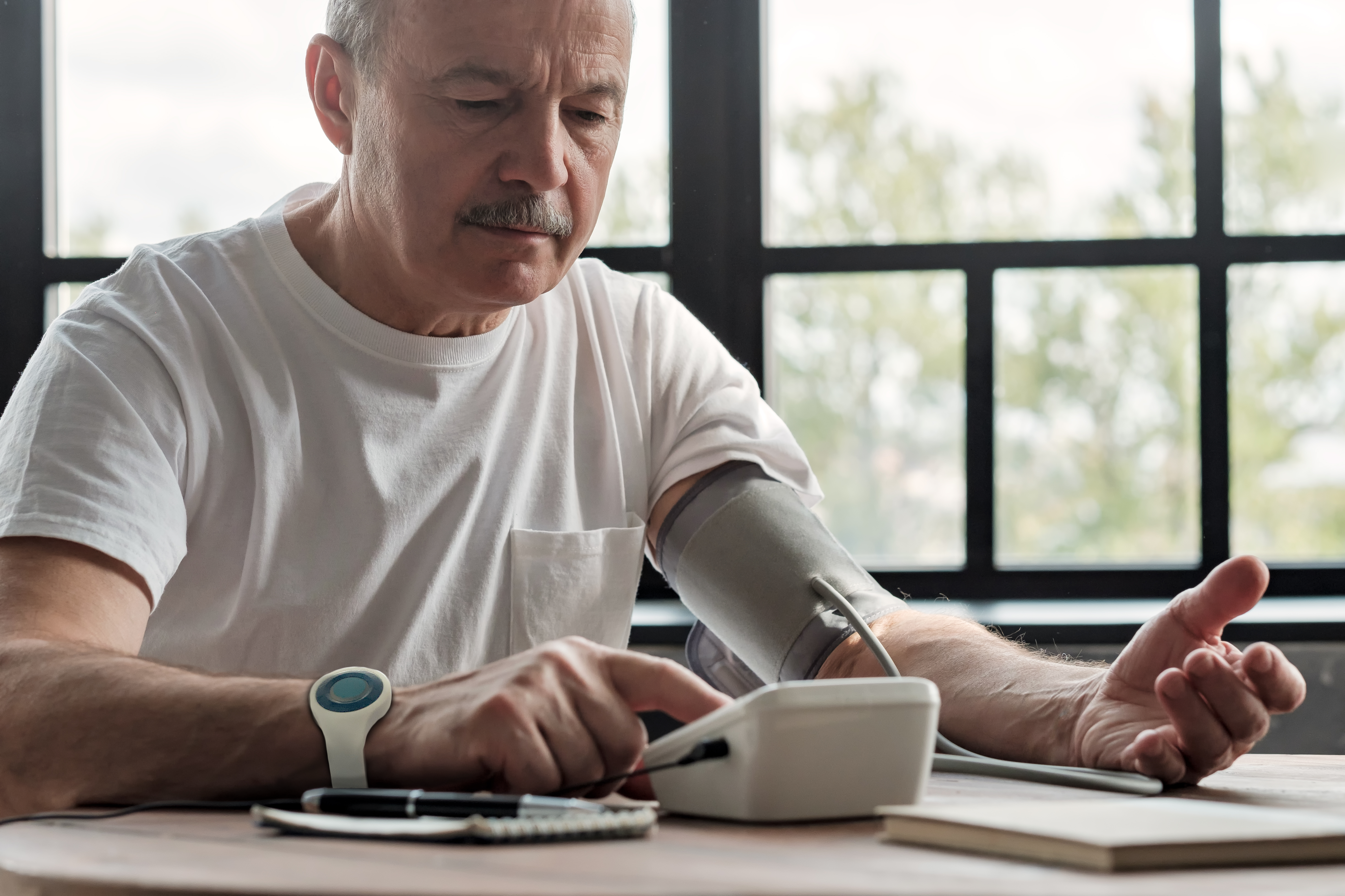 More and more adults are checking their own vitals at home and taking back control of their healthcare. This is an image of a man taking his own blood pressure. 
